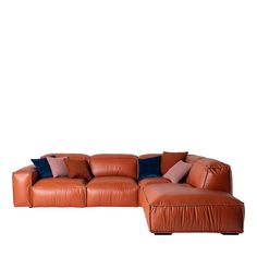 a brown leather sectional sofa with blue and pink pillows on the bottom half of it