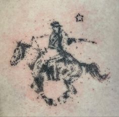 a man with a tattoo on his back riding a horse