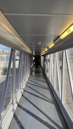 an empty walkway with lots of windows on both sides