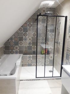 an attic bathroom with tiled walls and floor