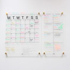 a white wall with two magnets on it and a calendar attached to the wall