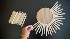 someone is making a sun shaped craft out of popsicle sticks and wood dows