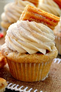 some cupcakes with frosting and cinnamon sticks on top