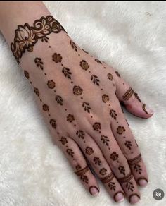 a woman's hand with hennap on it and flowers painted on the palm