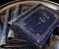 a bunch of books sitting on top of a metal plate with writing on them that says trick or treat