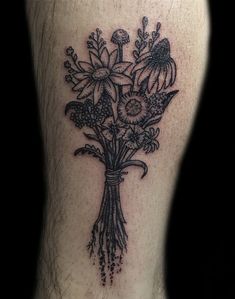 a black and white tattoo with flowers on the leg