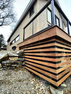 a wooden structure sitting on top of a pile of rocks next to a building with windows