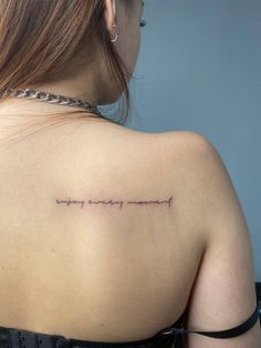 the back of a woman's shoulder with an inscription on it