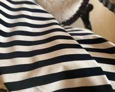 there is a black and white striped blanket on the bed with a dog in the background