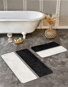 two bath mats sitting on top of a bathroom floor next to a bathtub and sink