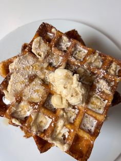 two waffles on a white plate covered in icing