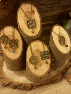 four pieces of wood with different pendants on them sitting on top of each other