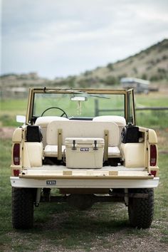 the back end of an old jeep with two seats on it's flatbed