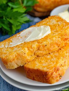 two pieces of bread on a plate with butter and parsley