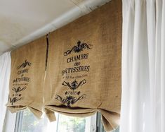 two burlocks hanging from the side of a window with french words on them