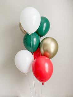 a bunch of balloons that are on top of each other in front of a white wall