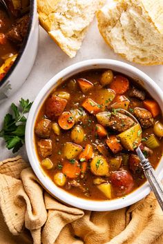 a bowl of stew with bread on the side