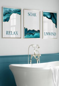 a bath tub sitting next to two pictures on the wall