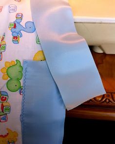 a baby's blue and white blanket on the edge of a sink