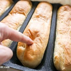 a person pointing at some bread in a pan