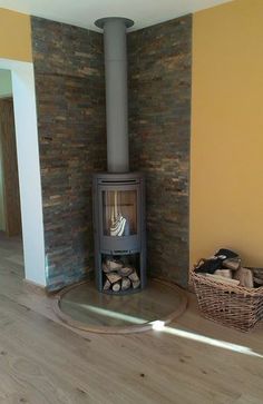 a wood burning stove sitting inside of a living room next to a pile of logs