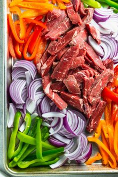 raw meat and vegetables on a tray ready to be cooked