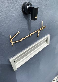 a close up of a door handle with the name kansanpa on it and a window sill