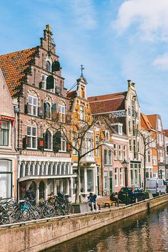 several bicycles parked on the side of a river in front of buildings with windows and balconies