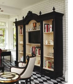 a black and white checkered floor with bookshelves in the middle, chairs on either side