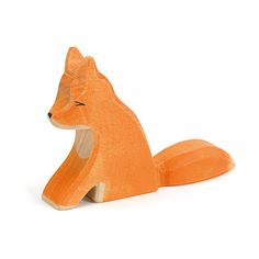 an orange wooden toy sitting on top of a white floor