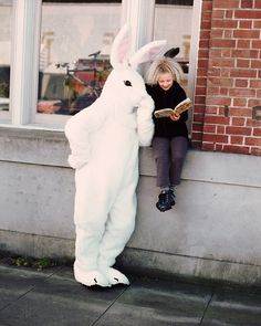 a woman in a bunny suit reading a book