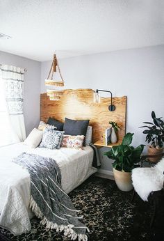 a bed room with a neatly made bed and plants