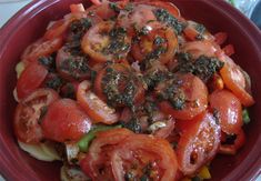 a red bowl filled with tomatoes and other vegetables