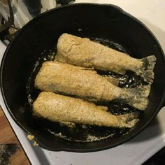 some food is cooking in a black skillet on the stove top and ready to be cooked