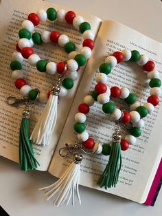 two tasseled bracelets are on top of an open book, one is green and the other is red