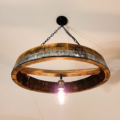 a light fixture made from an old barrel hanging from the ceiling in a room with white walls