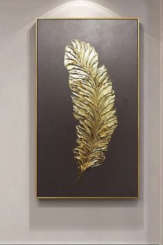 a large gold leaf is hanging on the wall in a room with white walls and flooring