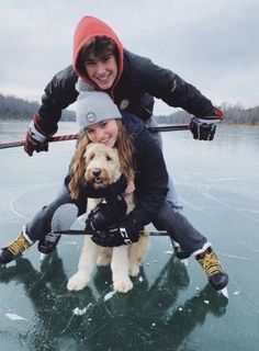 two people and a dog are on an ice - covered lake with their skis