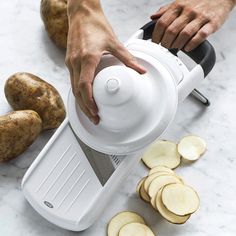 a person using a mandolin to cut potatoes