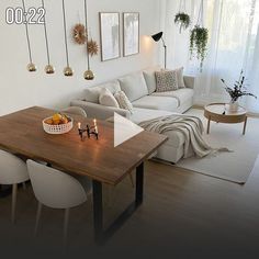 a living room filled with furniture next to a wooden table and white couches on top of a hard wood floor