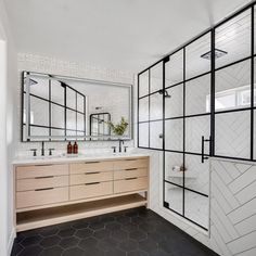 a bathroom with two sinks and mirrors on the wall, along with a walk in shower