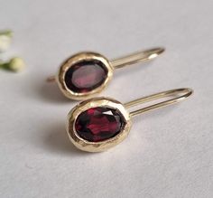 These red, oval Garnet earrings were made in a simple design to beautifully accompany you through your busy days. The classic simple design is always pretty for day and evening, work or fun. The earrings were carefully handmade and are very chic and elegant. The Garnet Earrings are available in 9k or 14k solid gold. They can be ordered with other stones as well.    These gold earrings are the perfect gift for a women. Dimensions: Oval length is 1 cm (0.4") Drop length is about 2 cm (0.8") Garnet Garnet Drop Earrings, Oval Earrings, Birthstone Earrings, Minimalist Gifts, Oval Earring, Red Gemstones, January Birthstone, Garnet Earrings, Earrings Red