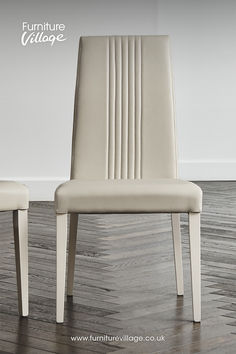 a pair of white chairs sitting on top of a wooden floor next to each other