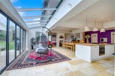 a living room filled with furniture next to a kitchen and an open floor plan area