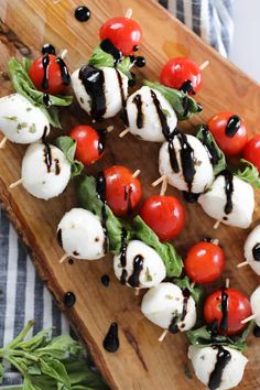 skewered tomatoes, mozzarella and black olives on a wooden platter