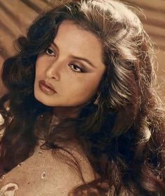 an old photo of a woman with long hair and brown eyeshadow, wearing a dress