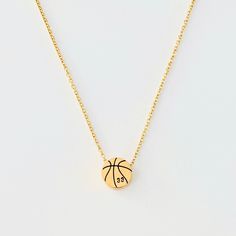 a gold necklace with a basketball on the front and an inscription that says, i'm