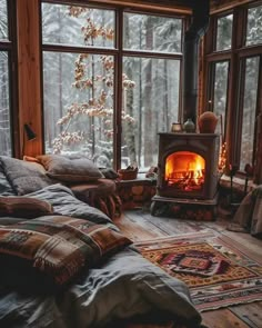 a bedroom with a wood burning stove in the corner and lots of pillows on the floor