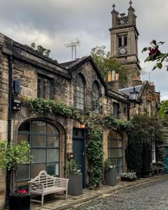 an old building with ivy growing on it and a clock tower in the back ground