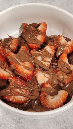 a bowl filled with chocolate and sliced strawberries